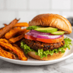 “Plated Air Fryer Baked Black Bean Burgers served with fresh toppings and sweet potato fries”