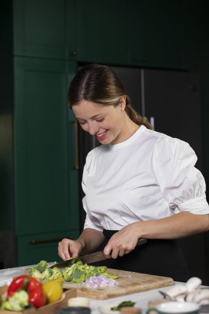 side view smiley woman cooking broccoli