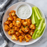 Crispy Air Fryer Buffalo Cauliflower served with ranch and celery.