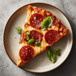 Perfectly reheated slice of pizza from air fryer with golden crust and melted cheese.