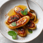 Golden air fryer bananas served warm with honey drizzle and cinnamon on a dessert plate”